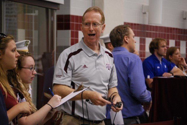Texas A&M coach Steve Bultman calls out splits to his managers; success in college swimming takes an effort of an army. Credit: Janna Schulze