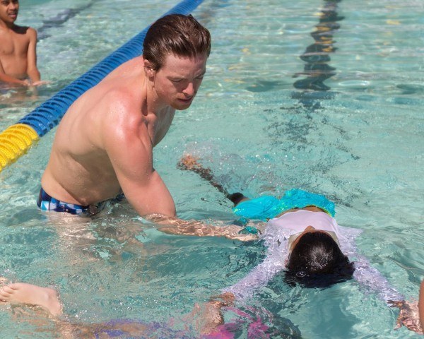 Connor Jaeger teaches swim lesson. "Ok, for your next lesson, let's try to the bicep flex!" (courtesy of Rafael Domeyko, domeykophotography.com)