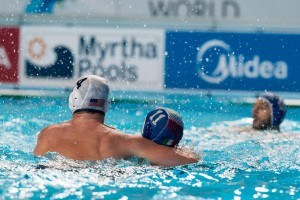Jackson Kimbell (4) of the U.S. shows that in water polo it's good to keep your friends close and your opponents offense closer in the team's match with Italy in the preliminary round at the 2015 FINA World Championship held in Kazan, Russia.