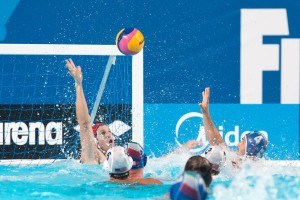 Peitro Figlioli of Italy lofts his teams fifth goal over the arms of U.S.A. goalie in preliminary round water polo competition at the 2015 FINA World Championship held in Kazan, Russia.